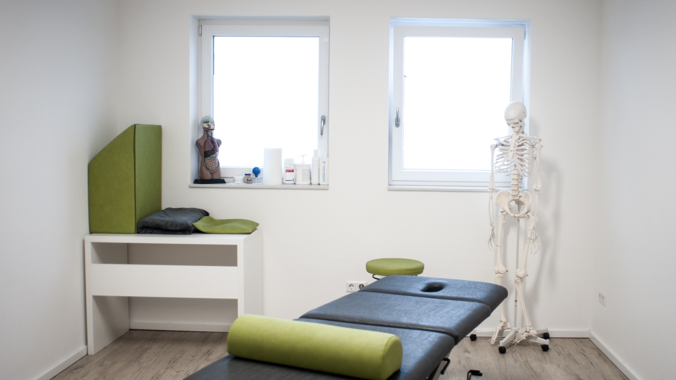Heller Behandlungsraum der Praxis mit Therapieliege